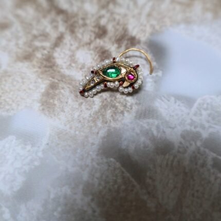 Handcrafted parrot-shaped Besar with emeralds, diamond polkis, and freshwater pearls – a striking mix of tradition and elegance.