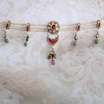 Choker set handcrafted with rubies, lush emeralds, and classic Kundan stones – traditional Indian jewelry for weddings and festive wear.