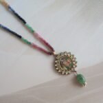 22kt gold Shreenath Ji pendant with diamond polkies, sapphires, emeralds, and ruby string layers – handcrafted traditional Indian temple jewelry.