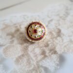 Rakhri with Kundan stones, takkar engraving, and freshwater pearls, traditional handcrafted design for bridal and festive wear.