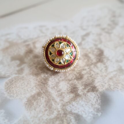 Rakhri with Kundan stones, takkar engraving, and freshwater pearls, traditional handcrafted design for bridal and festive wear.