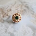 Rakhri with Kundan stones, freshwater pearls, and back enamelling, handcrafted in a traditional floral design.