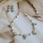 22kt gold choker set with Kundan stones and freshwater pearls, handcrafted in traditional Indian design.