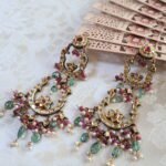 Traditional Indian earrings in 22kt gold with pearls, rubies, emeralds, and polki diamonds.